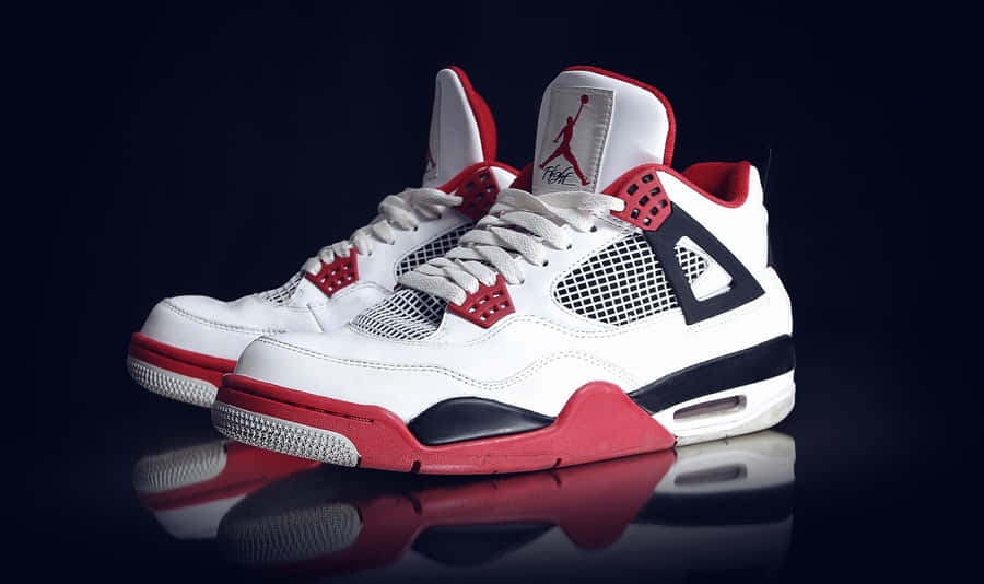A Pair Of White And Red Air Jordan 4 Sneakers Wallpaper