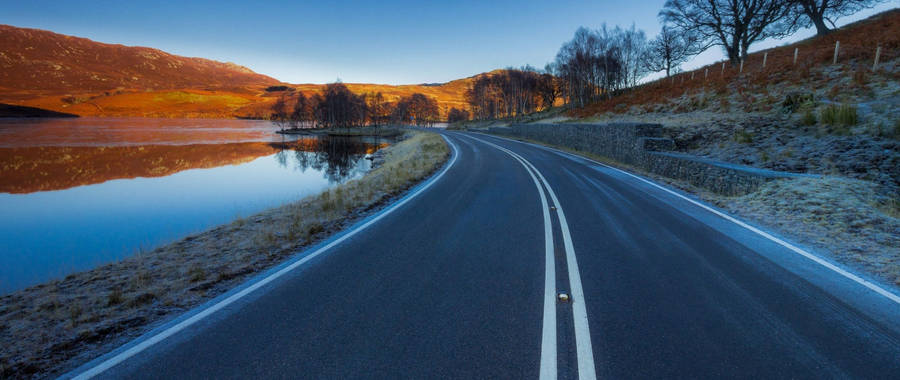 A Peaceful And Serene Country Road Wallpaper
