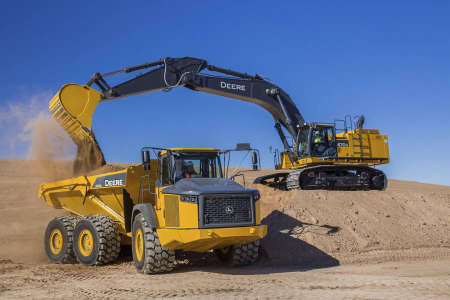 A Powerful John Deere Dump Truck And Excavator Working On A Construction Site Wallpaper