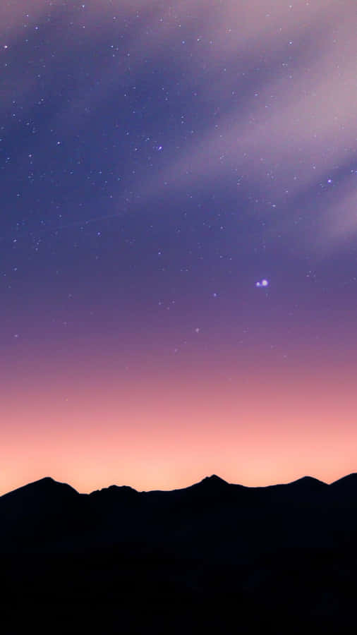 A Purple Sky With Stars And Mountains Wallpaper
