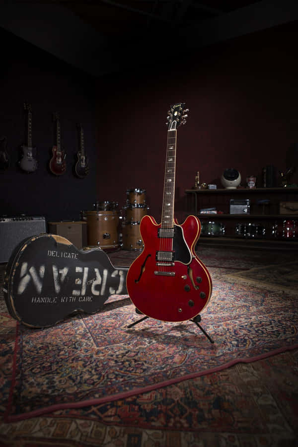 A Red Guitar Is Sitting On A Rug In A Room Wallpaper