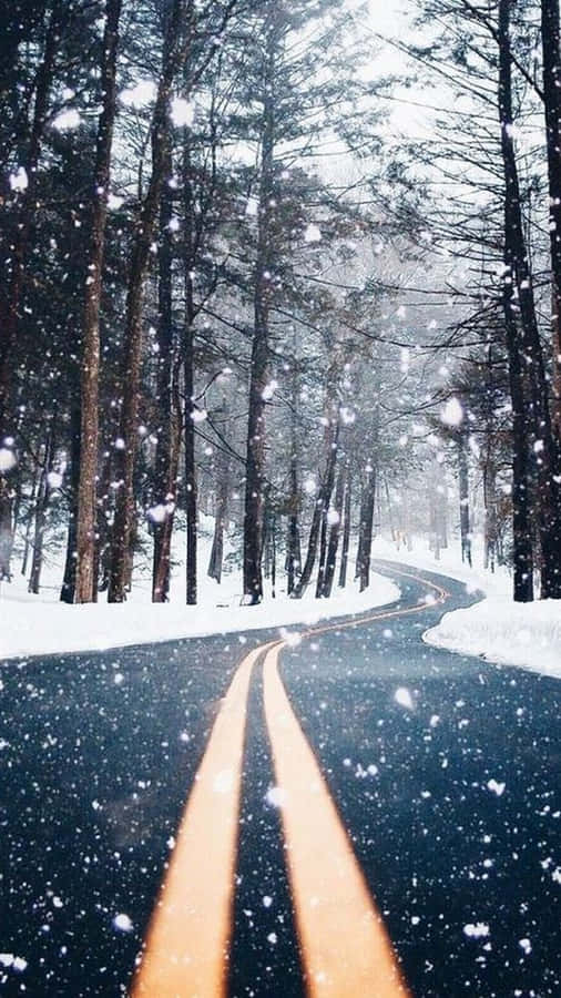 A Road In The Snow With Trees In The Background Wallpaper