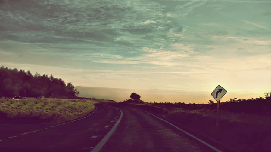 A Road With A Sign Wallpaper