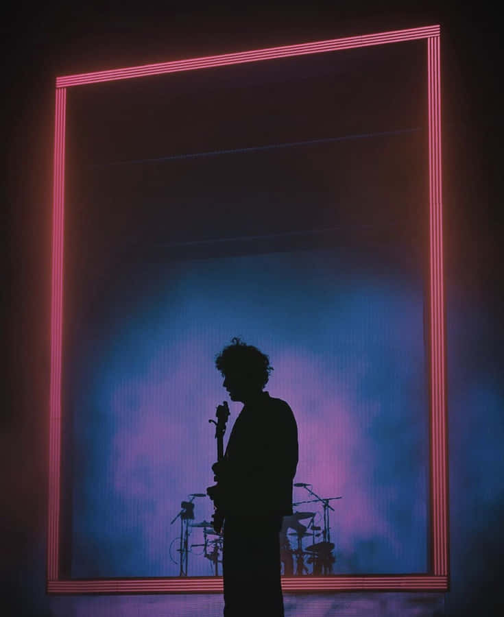 A Silhouette Of A Man Standing In Front Of A Large Neon Frame Wallpaper