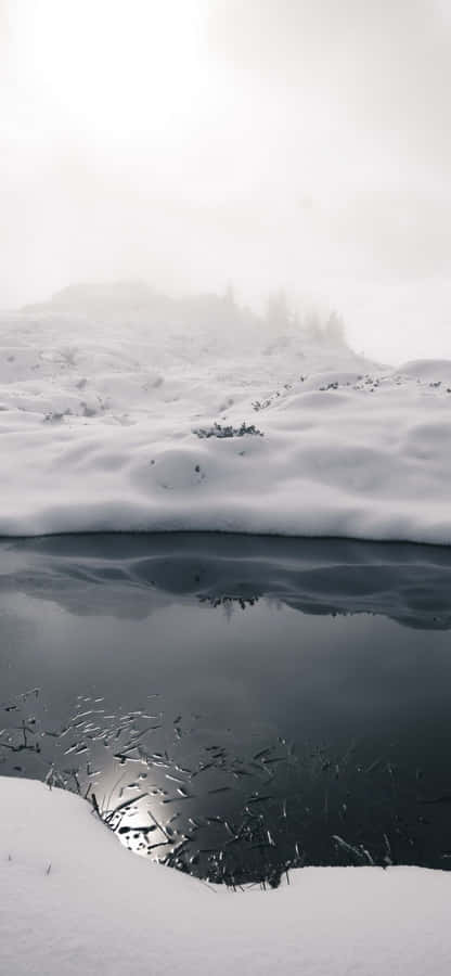 A Snow Covered Lake With A Reflection Wallpaper