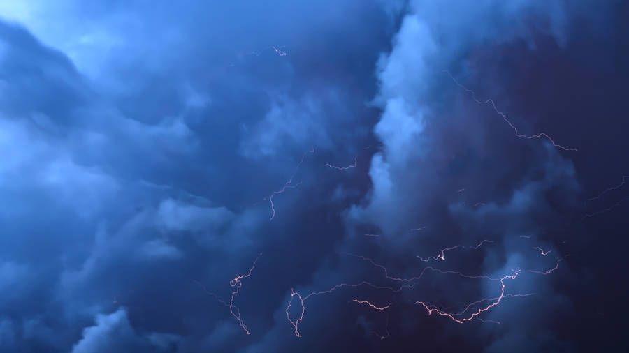 A Striking Streak Of Lightning In A Blue Cloud Wallpaper