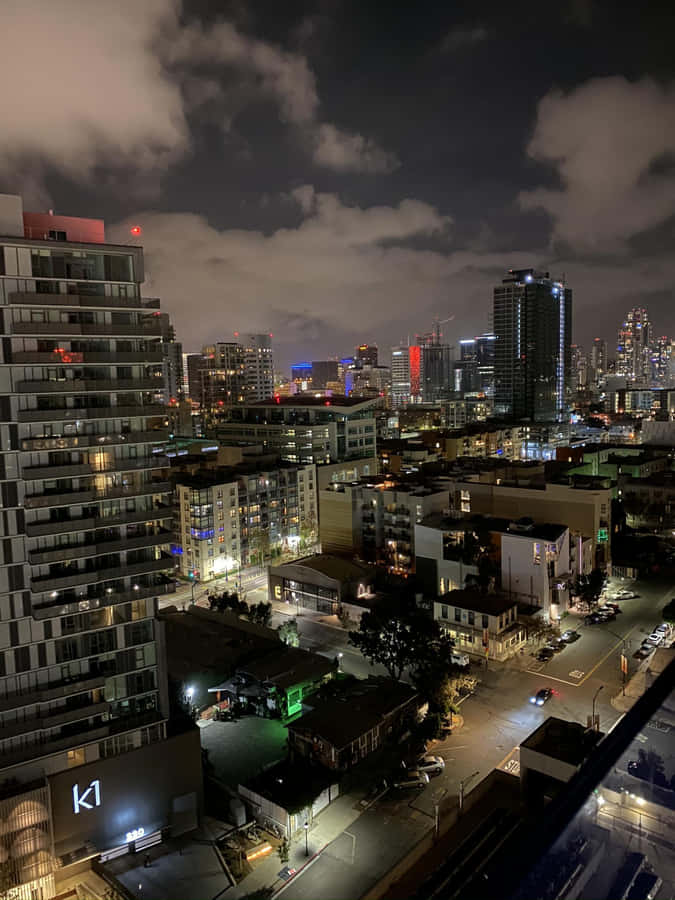 A View Of The City At Night From An Apartment Wallpaper