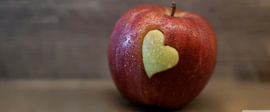 A View Of The Crisp And Colorful Apple Logo, Set Against A Powerful Background Wallpaper