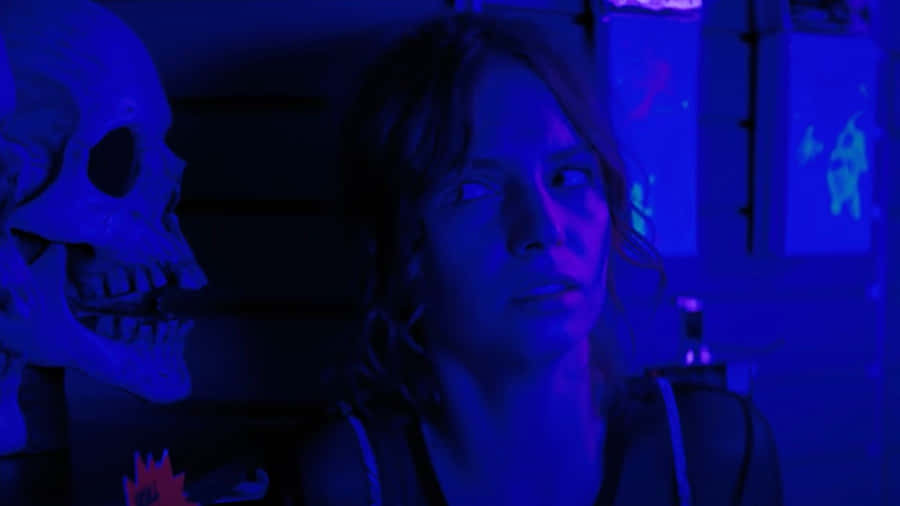 A Woman Is Standing In Front Of A Blue Wall Wallpaper