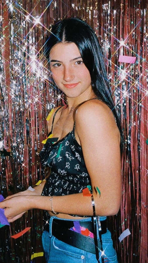 A Woman Is Standing In Front Of A Confetti Wall Wallpaper