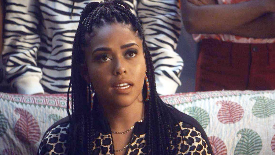 A Woman Sitting On A Couch With Braids Wallpaper