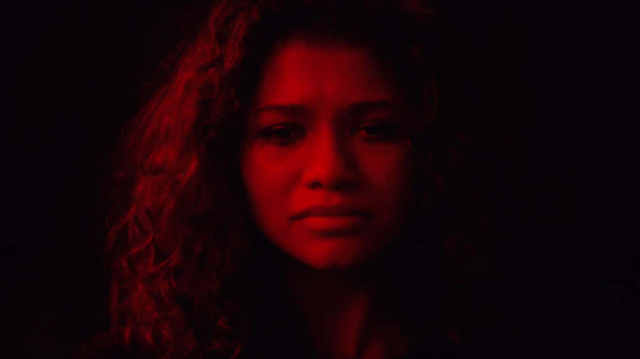 A Woman With Curly Hair In A Dark Room Wallpaper