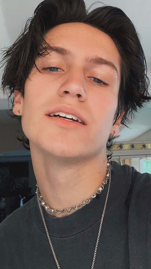 A Young Man With Long Hair And A Necklace Wallpaper