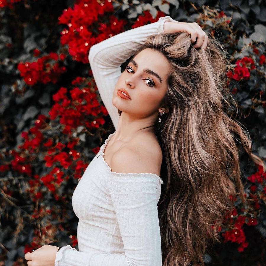 Addison Rae Posing Among Red Flowers Wallpaper