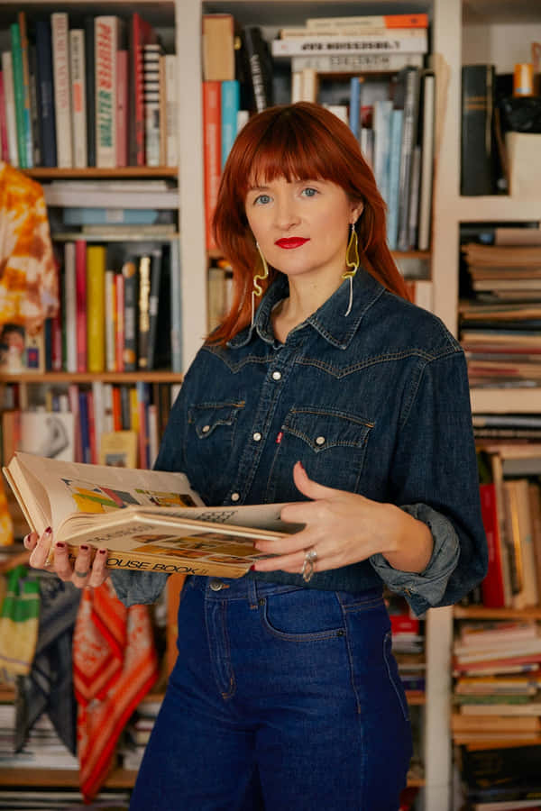 Amélie Pichard Against A Wall Of Books Wallpaper