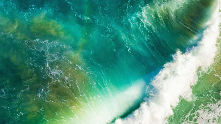 An Aerial View Of A Green Wave In The Ocean Wallpaper