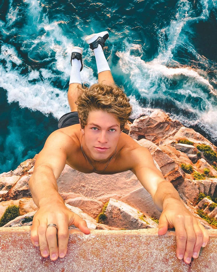 Ben Azelart Hanging On The Cliff Wallpaper