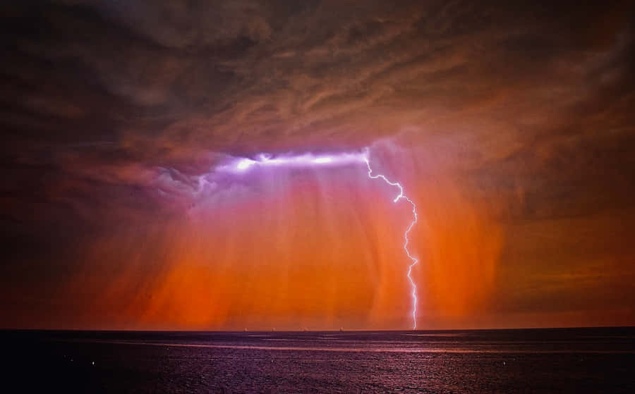 Bright Red Lightning Against A Dark Sky Wallpaper