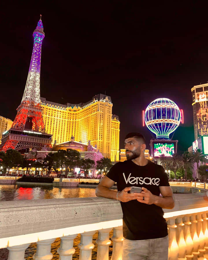 Caption: Amir Albazi Posing Beside An Eiffel Tower Replica Wallpaper