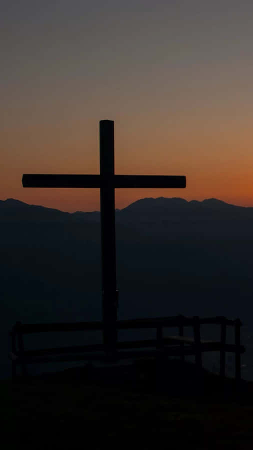 Caption: Divine Sanctity - A Gleaming Cross On Iphone. Wallpaper