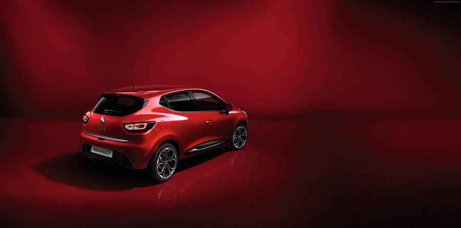 Caption: Elegant Red Renault Clio On Road Wallpaper