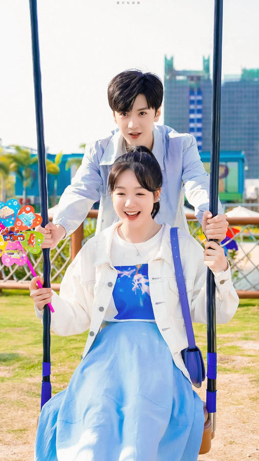 Caption: Romantic Korean Couple Enjoying A Swing Ride Wallpaper