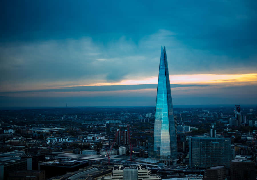 Caption: The Shard's Stunning Reflection Against The London Skyline Wallpaper