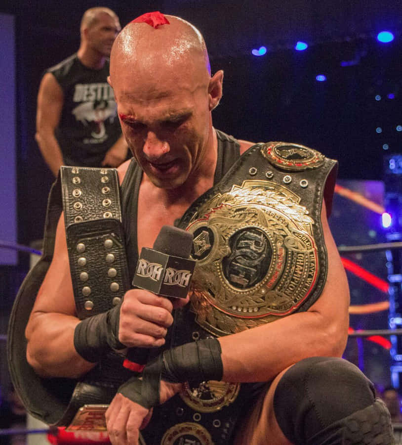 Christopher Daniels Triumphantly Holding The Roh Championship Belt Wallpaper