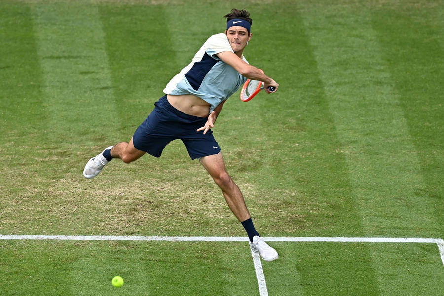 Concentrated Taylor Fritz Executing A Backhand Stroke Wallpaper