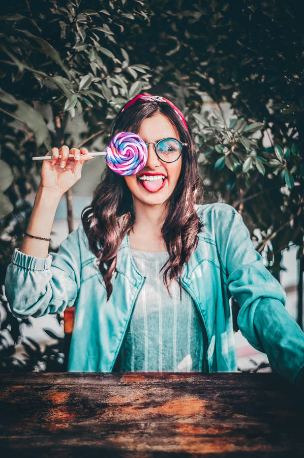 Cute Girl Wacky Pose With Lollipop Wallpaper