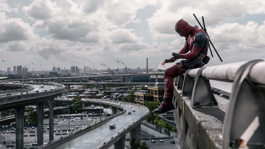 Deadpool - A Man Sitting On A Railing Wallpaper