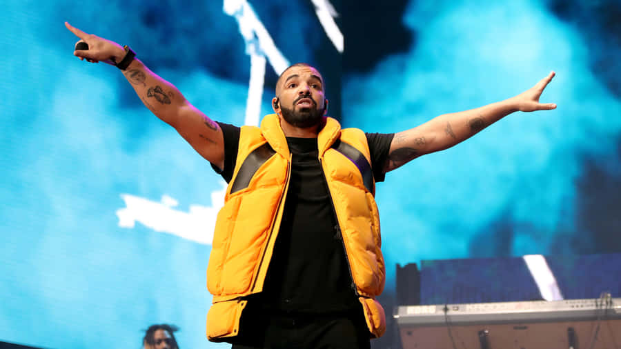 Drake Performs At A Concert With His Arms Outstretched Wallpaper