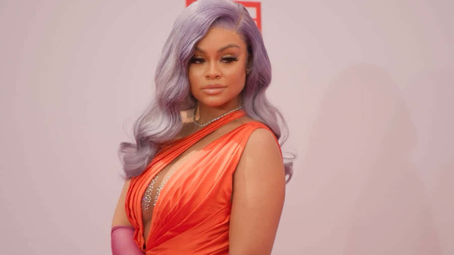 Elegant Celebrityin Orange Gown Wallpaper