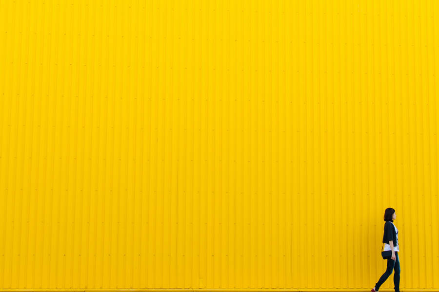 Embracing Boldness - Girl Against Yellow Wall Wallpaper