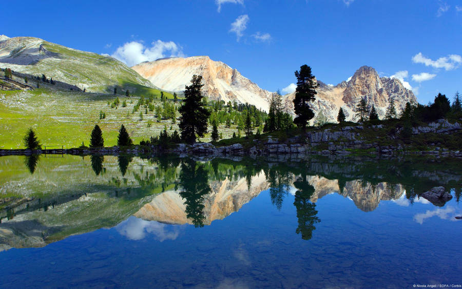 Enjoy The View From The Top Of A Green Mountain Wallpaper