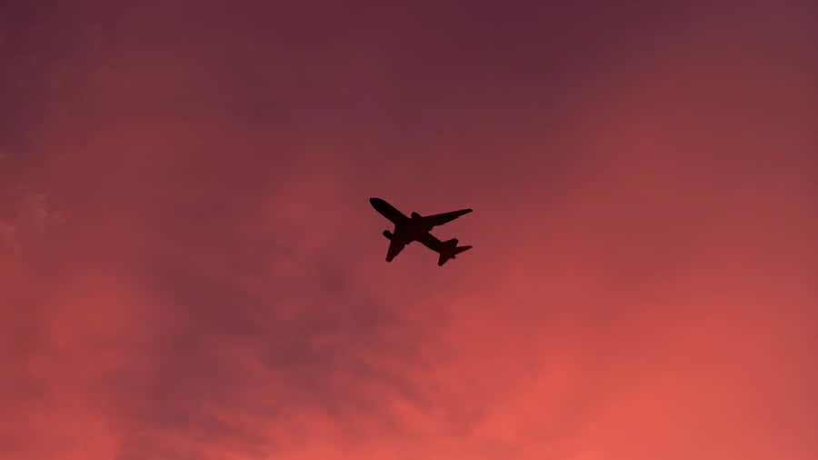 Experience The Beauty Of Flight In A Gorgeous Pink Plane Wallpaper