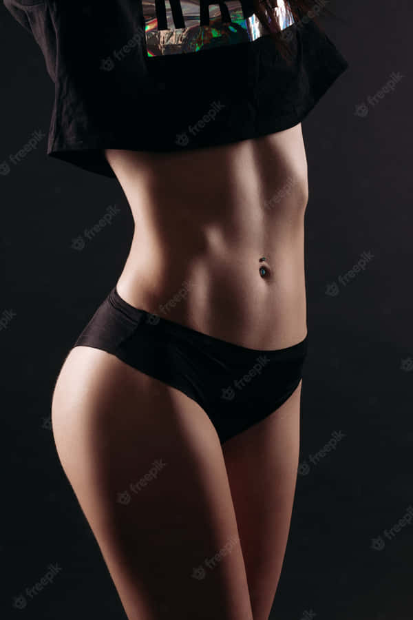 Fit Woman Showcasing Her Perfectly Toned Physique Against A Serene Nature Backdrop Wallpaper