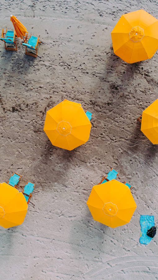 Five Yellow Umbrellas On Sand At Daytime Wallpaper