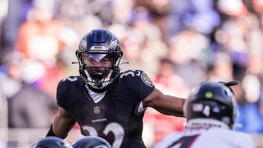 Focused Football Player Readyfor Action Wallpaper