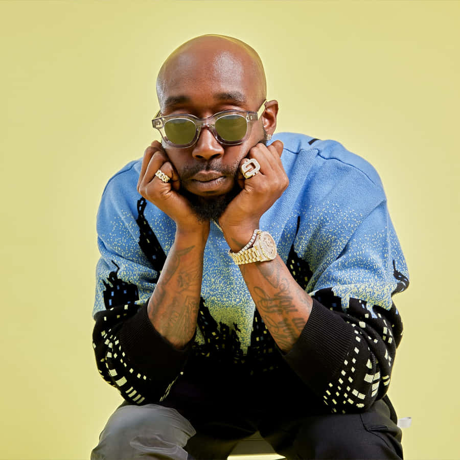 Freddie Gibbs Stylish Pose Yellow Background Wallpaper