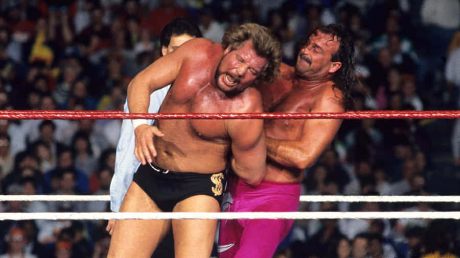 Jake Roberts Holding Ted Dibiase In A Rear Arm Lock Wallpaper