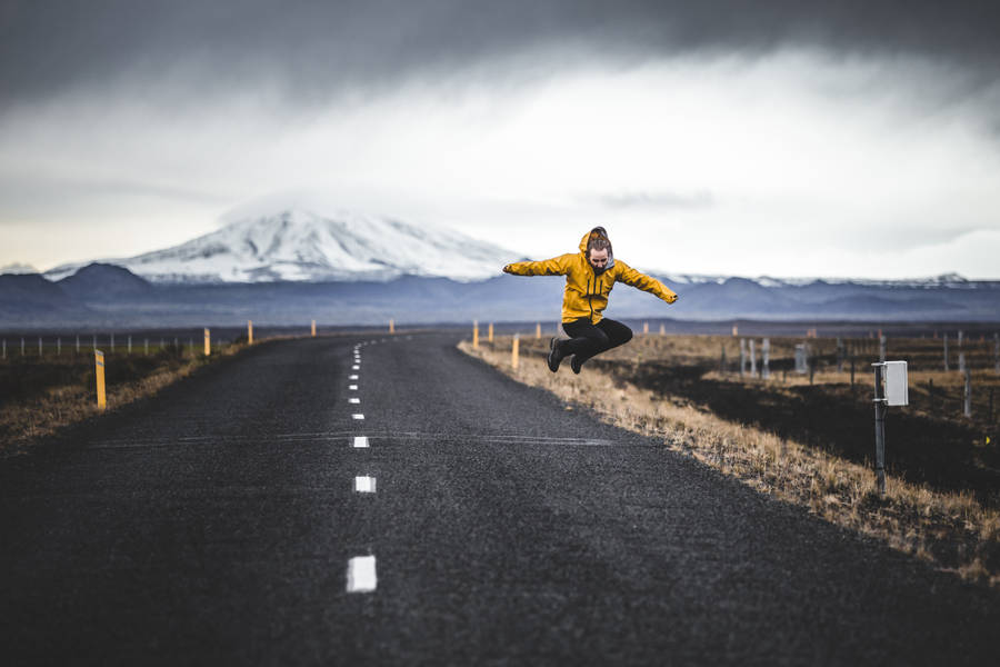 Jump Shot Photo Of Man Over Road And Mountain Alps At Distance Wallpaper