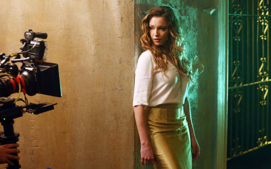 Katie Cassidy Posing In A Striking Red Dress Wallpaper