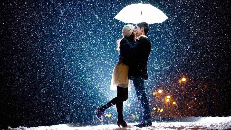 Korean Couple Kissing Amid Snowfall Wallpaper