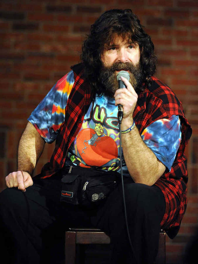 Legendary Wwe Hall Of Famer Mick Foley Delivering Engaging Comedy Chat. Wallpaper