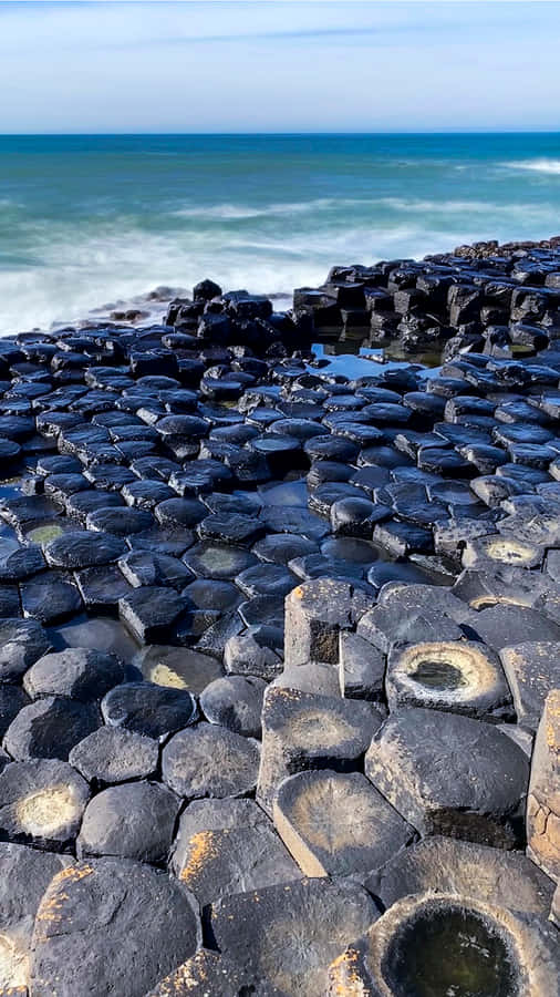 Magnificent View Of Giant's Causeway Against The Blue Ocean Wallpaper
