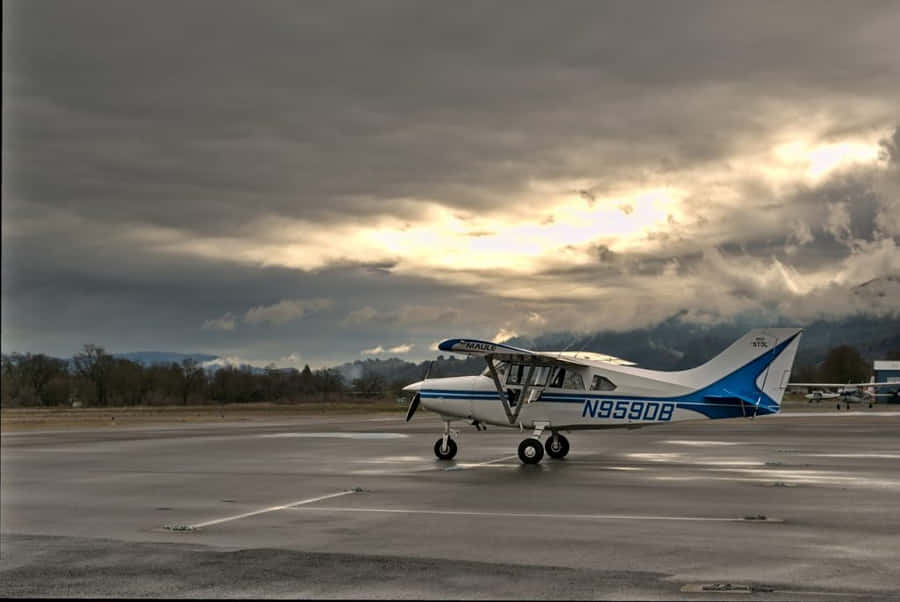 Majestic Small Airplane Resting On Airport Ground Wallpaper