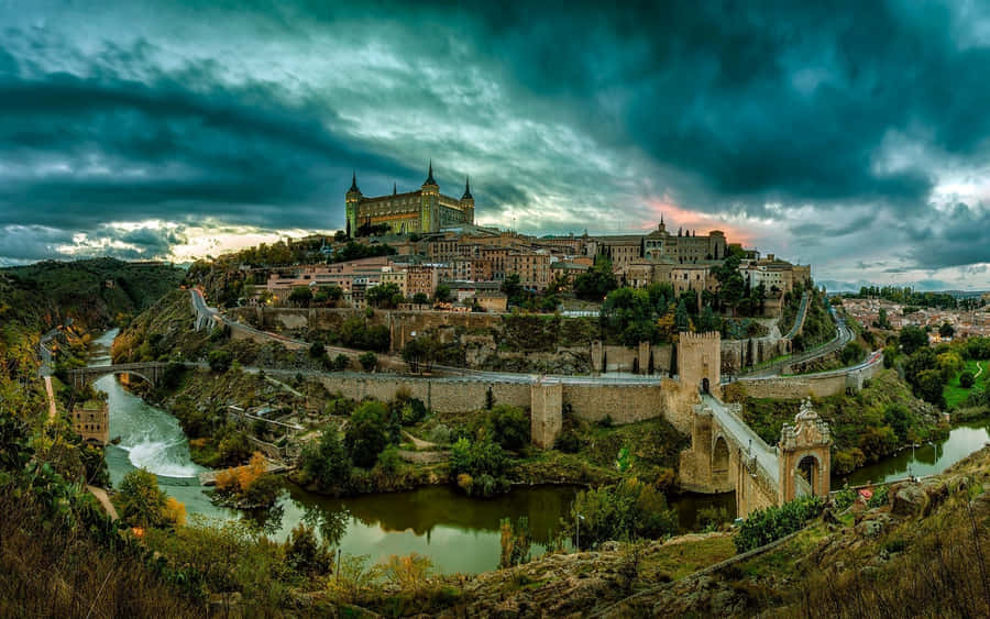 Majestic View Of Toledo Cathedral Under A Vibrant Blue Sky. Wallpaper
