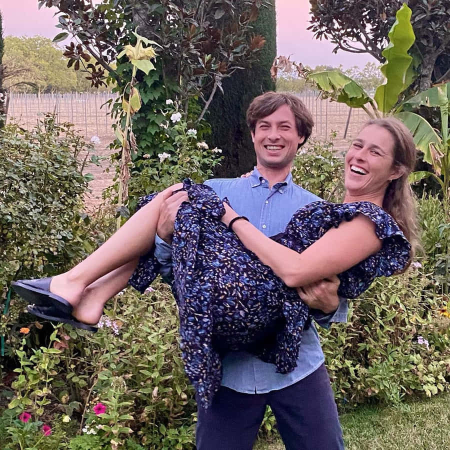 Man Carrying Womanin Garden Wallpaper