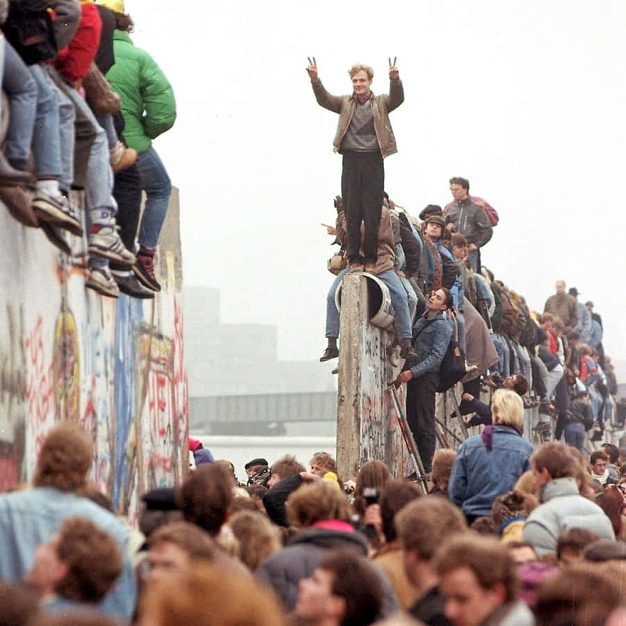 Man Doing Peace Sign On Berlin Wall Wallpaper